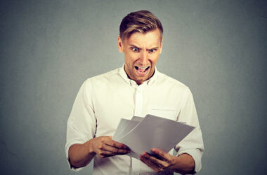 Man looking shocked at paperwork