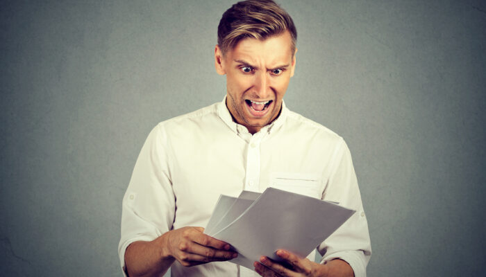 Man looking shocked at paperwork